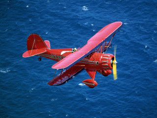Red airplane flying ocean yellow 2 - over the ocean free wallpaper