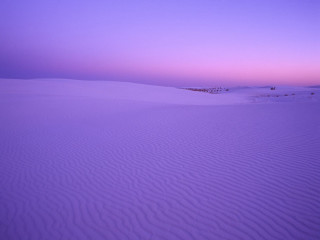 Purple sky sand dunes trees - a building in the distance free wallpaper