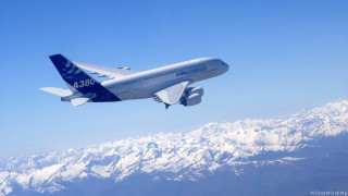 Large passenger jet mountain range - over a mountain range in the sky free wallpaper